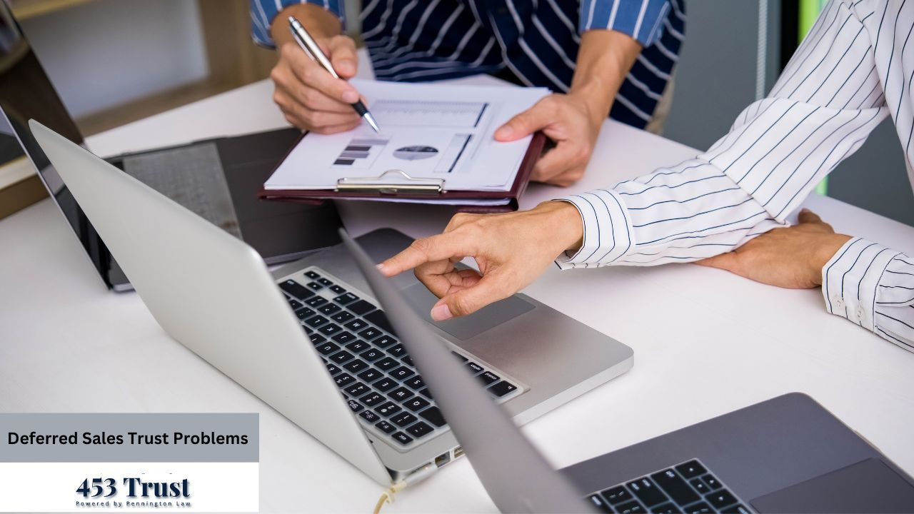 Two professionals are collaborating on a business matter, reviewing data on a laptop and a printed clipboard at a bright, modern desk.