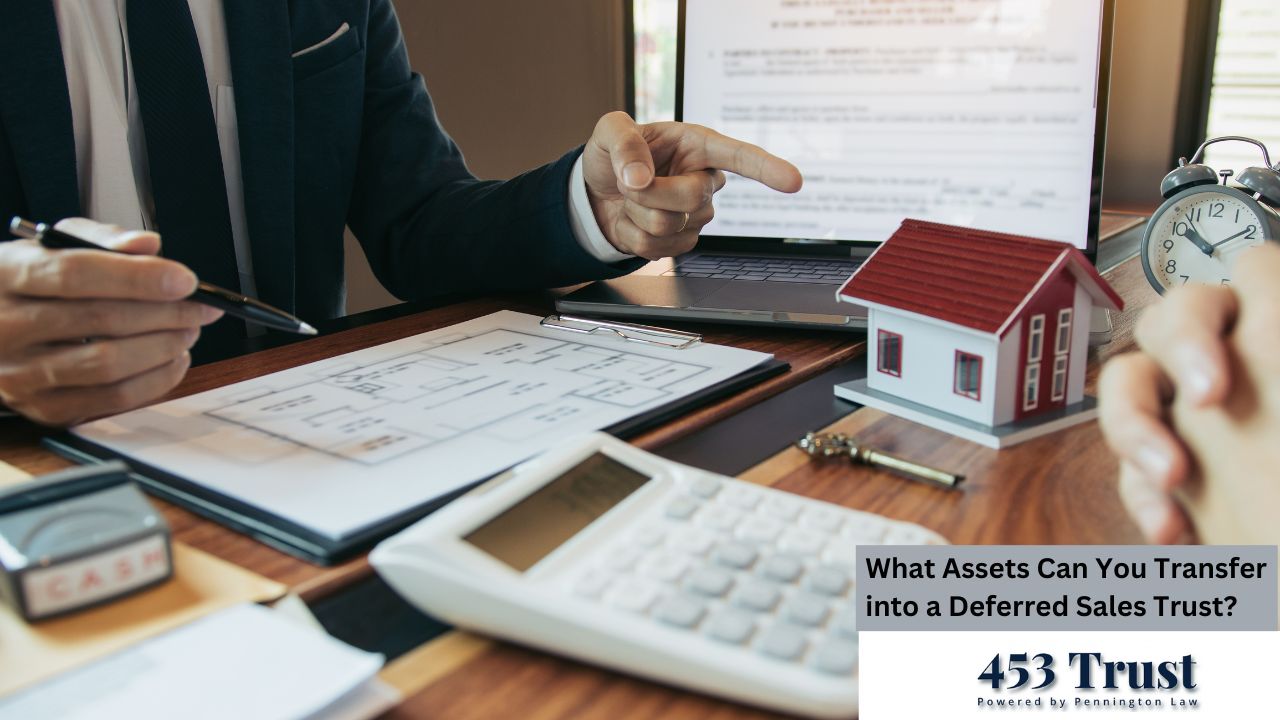 The image shows a close-up view of a wooden table where two individuals are seated. One person is dressed in a dark business suit and is actively engaged in the discussion, pointing to a document with a laptop displaying a contract visible in the background.